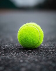 Bright Green Tennis Ball on Court Surface Captured in High Resolution and Vibrant Detail