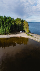 Travelers enjoy the peaceful beauty of Lake Saimaa, surrounded by lush forests and calm waters. A perfect day for a getaway in Finland, ideal for relaxation and adventure.