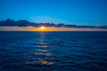 Dramatic ocean sunset with glowing clouds.
