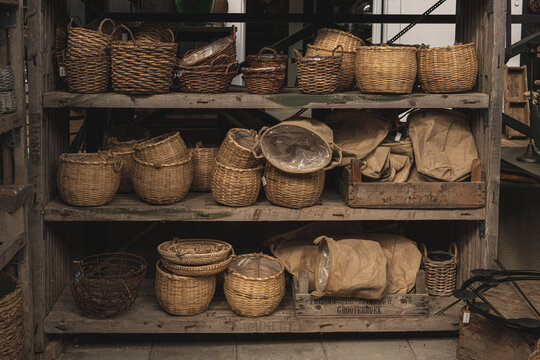 Collection of wicker baskets on wooden shelves.