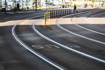 Curved tram tracks winding through city street.