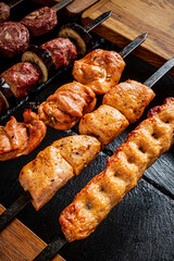 Colorful skewers of seasoned chicken and juicy beef await grilling on a warm evening