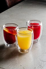 Three drinks in double-walled cups showcase vibrant colors, inviting refreshment and conversation