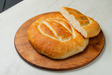 Warm, freshly baked bread sits on a wooden board, inviting and ready to be enjoyed