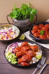 Colorful and appetizing plate of homemade meatballs served with with rice, avocado and creamy coleslaw