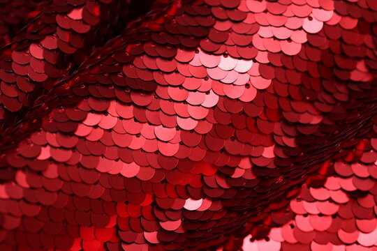 Close-up of matte finish spangle fabric in metallic red tones, showcasing layered sequins with subtle shine and textured surface, ideal for fashion and textile design.