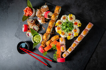 A stunning display of sushi rolls and garnishes on a dark surface, ready to enjoy