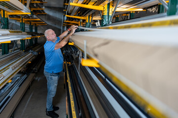 Control of materials for the production of PVC and aluminum profiles. A senior craftsman selects the material for the production of windows and doors.
