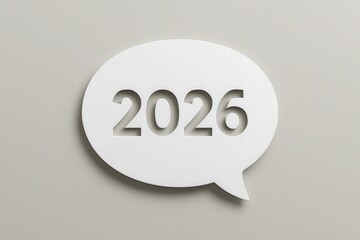 Speech bubble with the year 2026 cut out, displayed against a muted, pale grey background, evoking themes of planning, future, time, and communication.