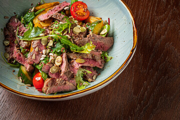 Freshly prepared salad features tender grilled steak, colorful vegetables, and crunchy seeds