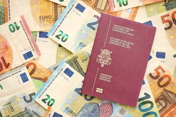 Belgium passport lies on big amount of euro money banknotes. Rich life and travel in Europe