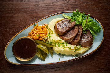 This dish features tender beef, creamy mashed potatoes, fresh greens, and pickled veggies