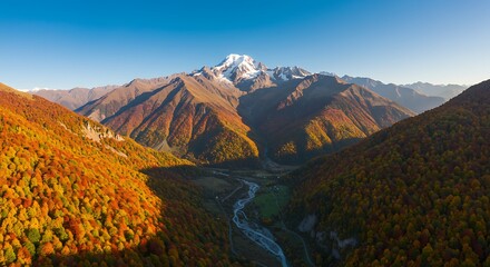 Majestic mountain range scenery with autumnal foliage and a clear blue sky