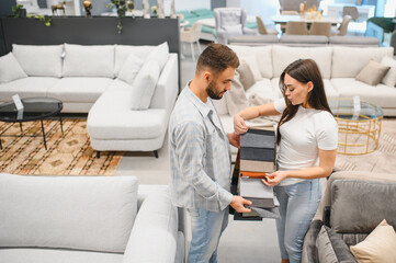 Naklejka premium Couple choosing furniture fabric swatches in store