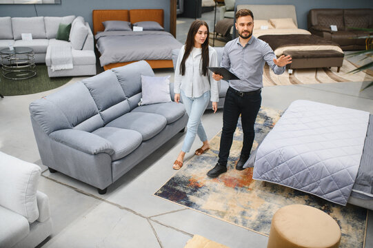 Female client choosing furniture with sales consultant