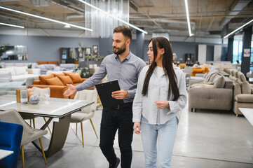 Sales consultant helping woman choosing furniture in store