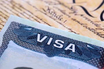 US visa stamped on a passport page with USA Constitution page background