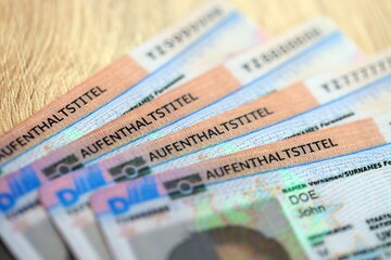 German Permanent resident specimen cards lies on wooden table. Aufenthaltstitel