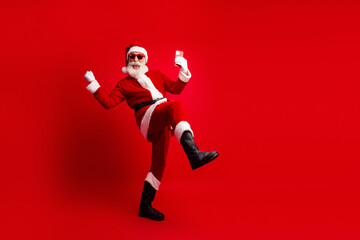 Santa Claus in a vibrant pose holding a smartphone against a bold red background, celebrating festive cheer