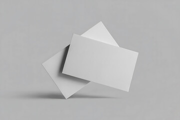 Two blank white rectangular cards overlapping on a light gray background paper rectangle