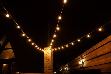 Beautiful outdoor lighting with modern warm night lamps decoration for atmosphere. Patio zone near the house.