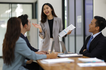 Asian businesswoman leader discussing business planning idea presentation with colleagues in conference room at office.