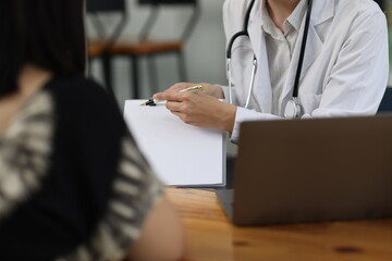 Female doctor is smiling at her pregnant patient during a consultation in a medical office, providing compassionate care and support