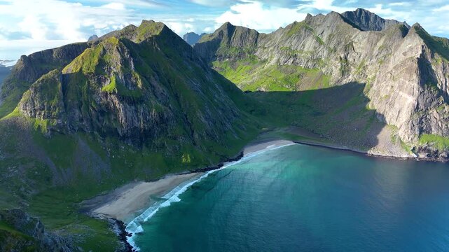 Discover the stunning vistas along the Ryten Kvalvika Trail in Lofoten, Norway, where lush green mountains meet serene sandy beaches. A perfect destination for nature lovers and hikers.