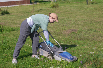 woman cutting grass with lawn mower