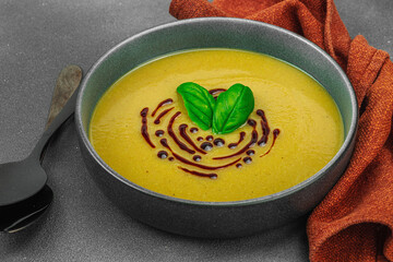 Creamy pattypan squash soup, garnished with basil and balsamic glaze, served in a trendy bowl