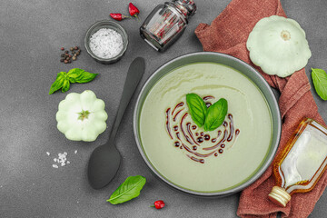 Creamy pattypan squash soup, garnished with basil and balsamic glaze, served in a trendy bowl