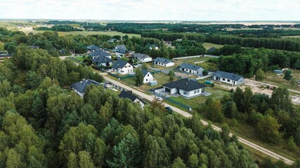 Drone shot revealing a luxurious detached house with garden surrounded by forest, showing the contrast between nature and architecture © AlexGo