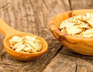 Wooden bowl and spoon filled with rolled oats on a rustic wooden surface