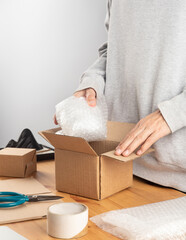 Close up of a man packing a box for delivery to the customer