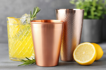 Elegant cocktail setup showcases copper tools, glassware, fresh lemons, and herbs, creating a refined atmosphere for drink enthusiasts and gatherings