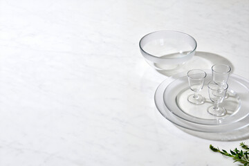 Minimalist Glass Dinnerware Setting with Shot Glasses on Marble