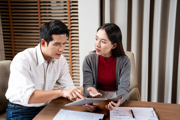 Two asian business persons working together. Businessman brainstorming, having a discussion with...
