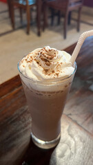 Coffee latte in glasses cups with vanilla pods, foam, milkshake on table in cafe