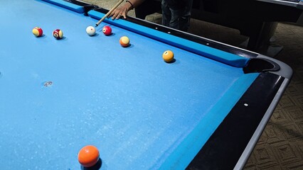 Casual Pool Night: Player Aims At Balls On Blue Felt Pool Table In Club