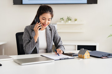 Confident asian business lady, broker real estate agent or manager, sitting at table in a modern...