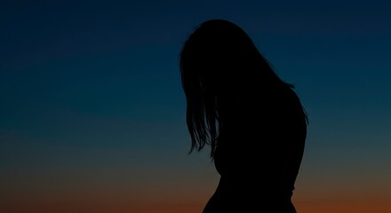 Silhouette of a woman against a dusky sky evokes themes of introspection and solitude