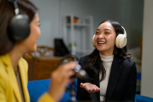 Women podcasting, communicating and laughing during an interview