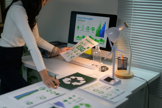 Businesswoman analyzing ESG environment report at office desk