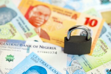 Nigerian naira currency money bills and padlock. The concept of sanctions and financial safety