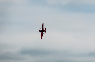 An aerobatic pilot in an aerobatic propeller plane shows off his