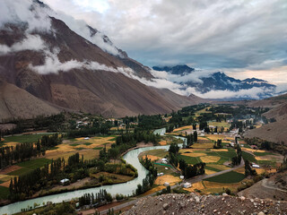 A wide angle landscape view of Gilgit River passing through agricultural fields, trees, houses and mountains of Phander Valley situated in Ghizer, Gilgit Baltistan, Pakistan. © SyedUsmanPhotography