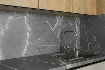 Grey table top, stainless steel sink with water tap, against a grey wall, minimalistic kitchen cabinets