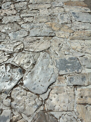 Ancient shiny stone floor in greys and creams, unique shapes and shadows, perfect for textured background use.