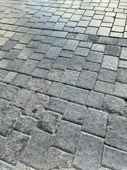 Worn grey rectangular bricks in a sleek perspective pattern, shiny with age, making a strong textured background.
