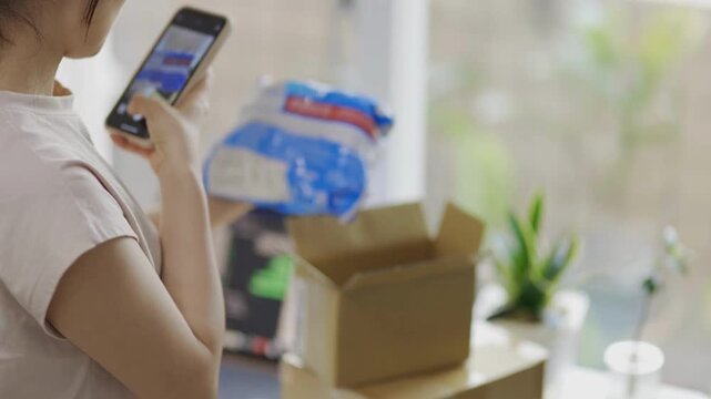 a young female taking photo of product goods item from online purchase